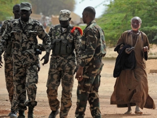 Le soldat enragé (à gauche) est séparé de sa victime par d'autres militaires qui ont gardé leur sang-froid. L'agresseur porte en bandoulière l'appareil photo de Salifou Bouaré, confisqué quelques minutes plus tôt. © Mehdi Chebil